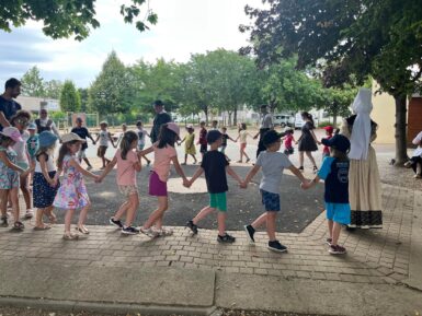 Enfants qui dansent en ronde dans la cour de l'école
