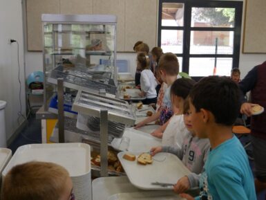Enfants avec un plateau attendant pour le self