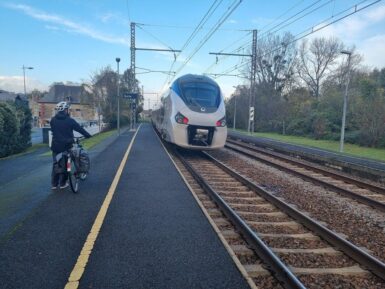 Cycliste sur le quai de la gare de Jaunay-Marigny dont part un TER