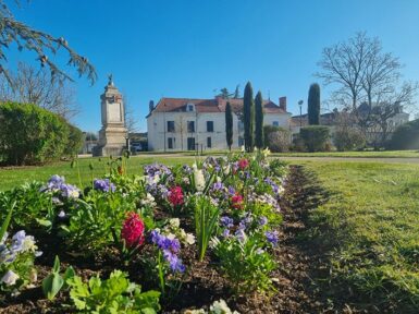 Parterre fleuri au printemps devant le monument aux morts