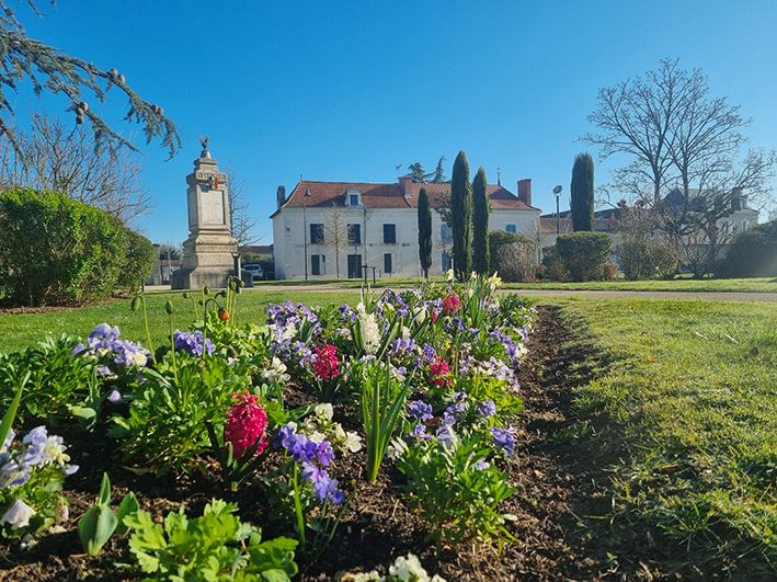 Parterre fleuri au printemps devant le monument aux morts