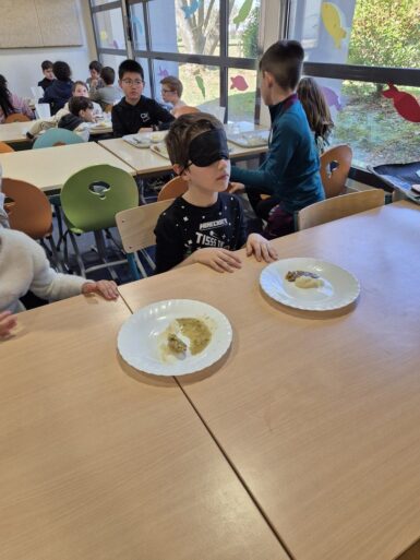 Enfant avec les yeux bandés qui teste des saveurs