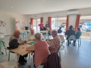 Seniors en train de jouer aux cartes dans la salle d'activités de l'espace Millésime