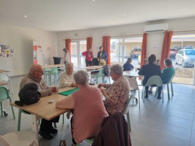 Seniors en train de jouer aux cartes dans la salle d'activités de l'espace Millésime
