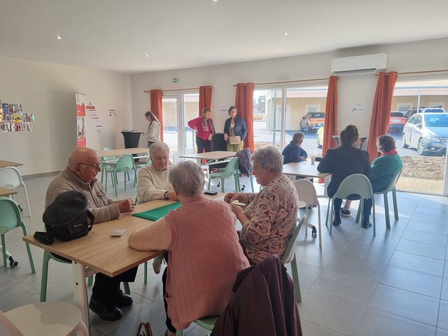 Seniors en train de jouer aux cartes dans la salle d'activités de l'espace Millésime