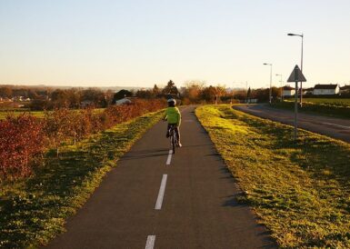 Enfant roulant à vélo sur une piste cyclable au coucher du soleil