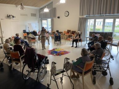 Résidents de l'Ehpad en cercle lors d'une activité dans la salle d'animation.