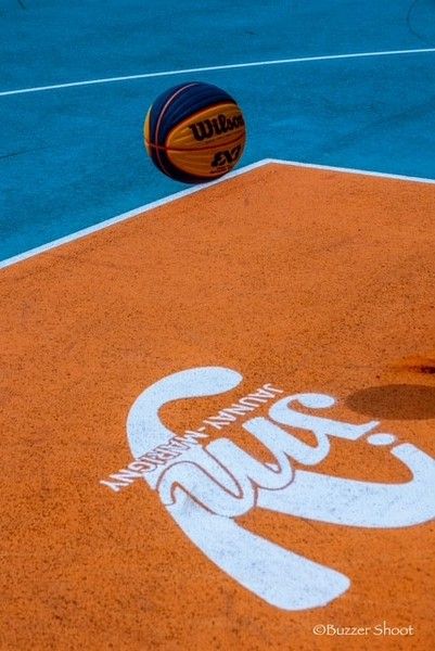 Ballon de basket au vol au dessus d'un terrain de 3x3 marqué avec le logo Jaunay-Marigny