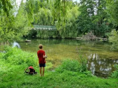 Jeune garçon en train de pêcher au bord de la rivière le Clain