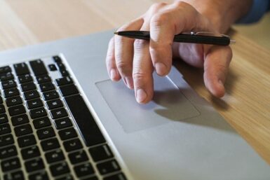 Main d'homme sur le pad d'un clavier d'ordinateur portable