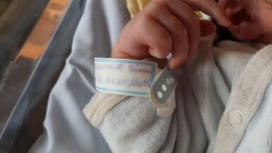 Main de bébé avec bracelet de naissance