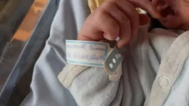 Main de bébé avec bracelet de naissance