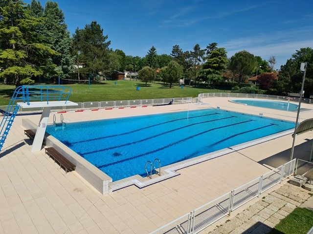 Vue d'ensemble sur le parc, le grand bassin et la pataugeoire de la piscine