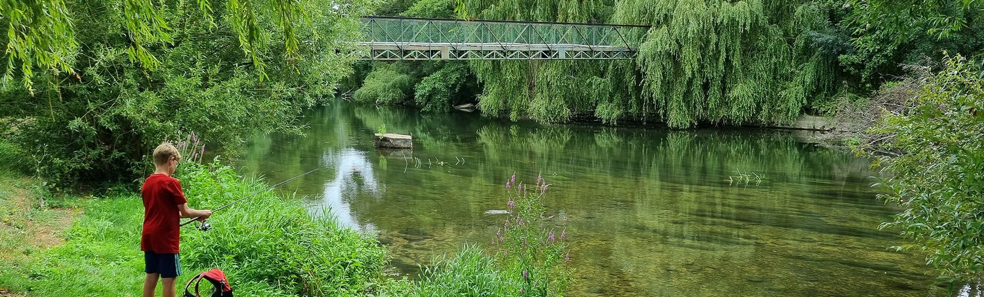 Jeune garçon pêchant au bord de la rivière le Clain