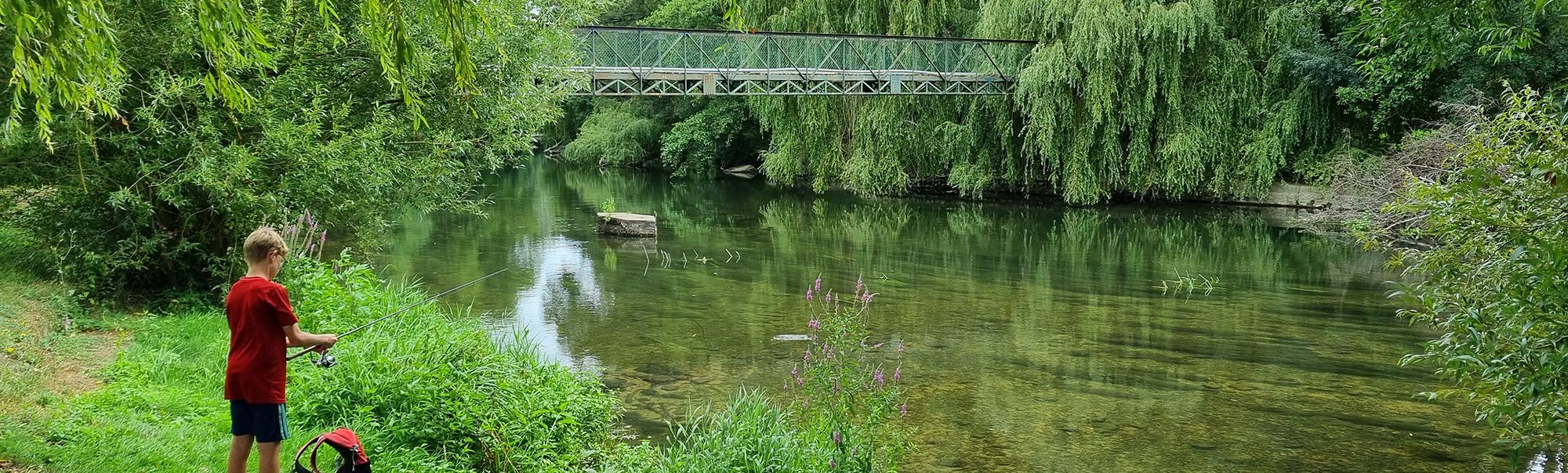 Jeune garçon pêchant au bord de la rivière le Clain