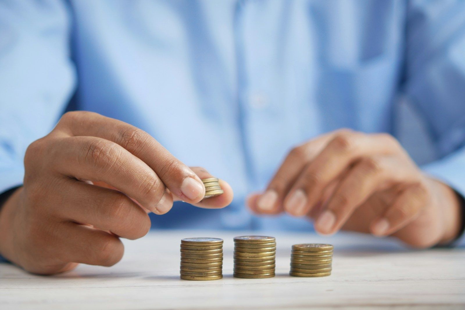 Personne alignant des pièces de monnaie en différentes piles