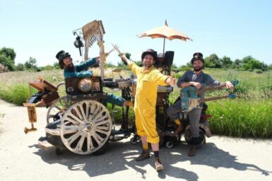 les trois artistes du groupe les trimardeurs sur leur locomobile