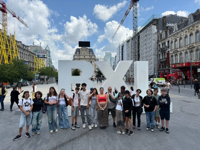 Groupe d'adolescents à Bruxelles devant les lettres géantes BXL