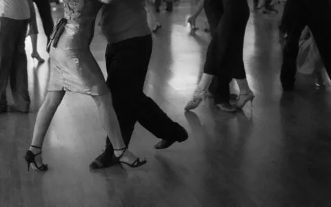 People are dancing on a wooden floor.