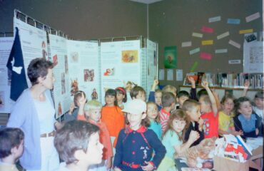Groupe d'élèves devant un panneau d'exposition dans l'ancienne bibliothèque.