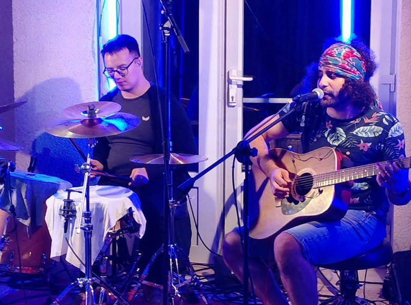 Le batteur et le guitariste du groupe Strum & Poum sur scène.