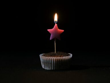 a cupcake with a lit candle sticking out of it