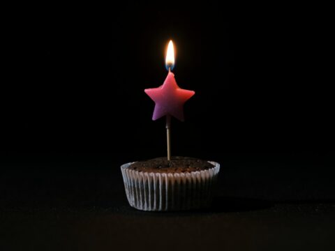 a cupcake with a lit candle sticking out of it