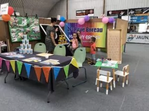 Stand de l'association au forum des association décoré d'une banderole colorée au nom de l'association et de plusieurs jeux type chamboultout