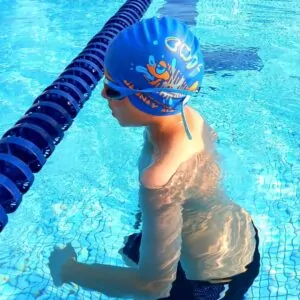 Enfant avec un bonnet de bain aux couleurs du club