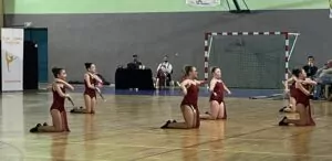 5 jeunes filles font du twirling dans le gymnase d