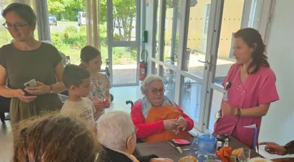 Résidents à l'heure du déjeuner déballant les petits cadeaux confectionnés par les enfants de l'école René Cassin.