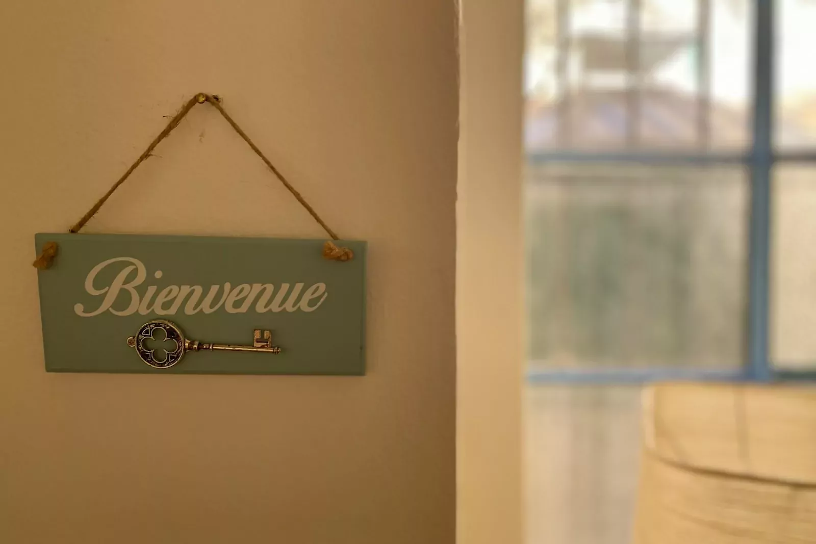 a blue sign hanging on a wall next to a window