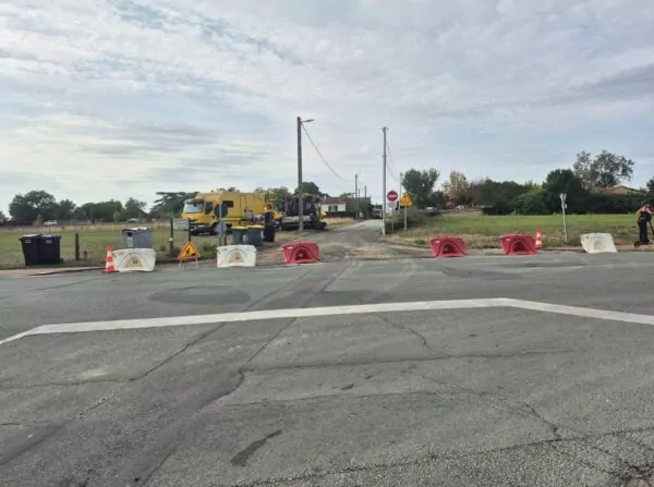 rue de la Haute Payre à Jaunay-Marigny bloquée avec des plots en raison de travaux un tractopelle est stationné sur le côté.