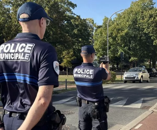 Deux policiers procèdent à un contrôle de vitesse à l'aide d'un radar mobile rue des écoles à Jaunay-Marigny.